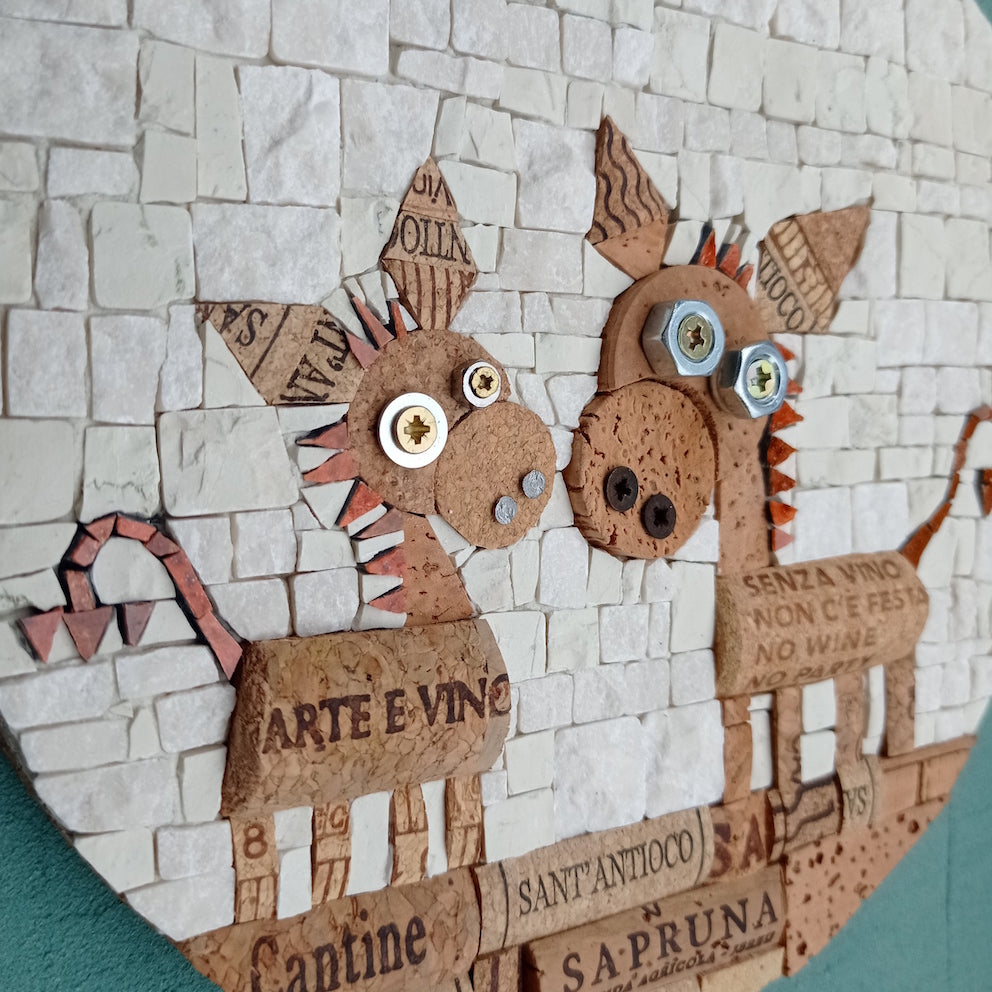 mosaico rotondo di diametro 18 cm, raffigurati due simpatici ciuchini realizzati con sughero recuperato dai tappi di bottiglia, sfondo bianco in marmo. dettaglio