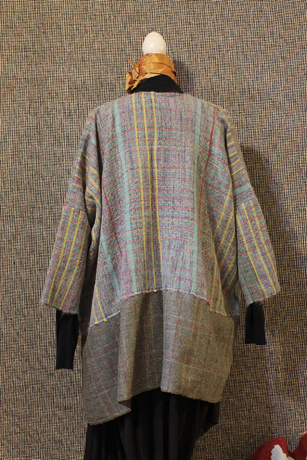 giacca tessuta a mano con telaio tradizionale, vista di spalle su manichino
